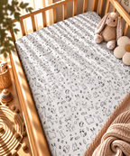 Black and White Woodland Crib Sheet fitted in a wooden crib with a plush toy