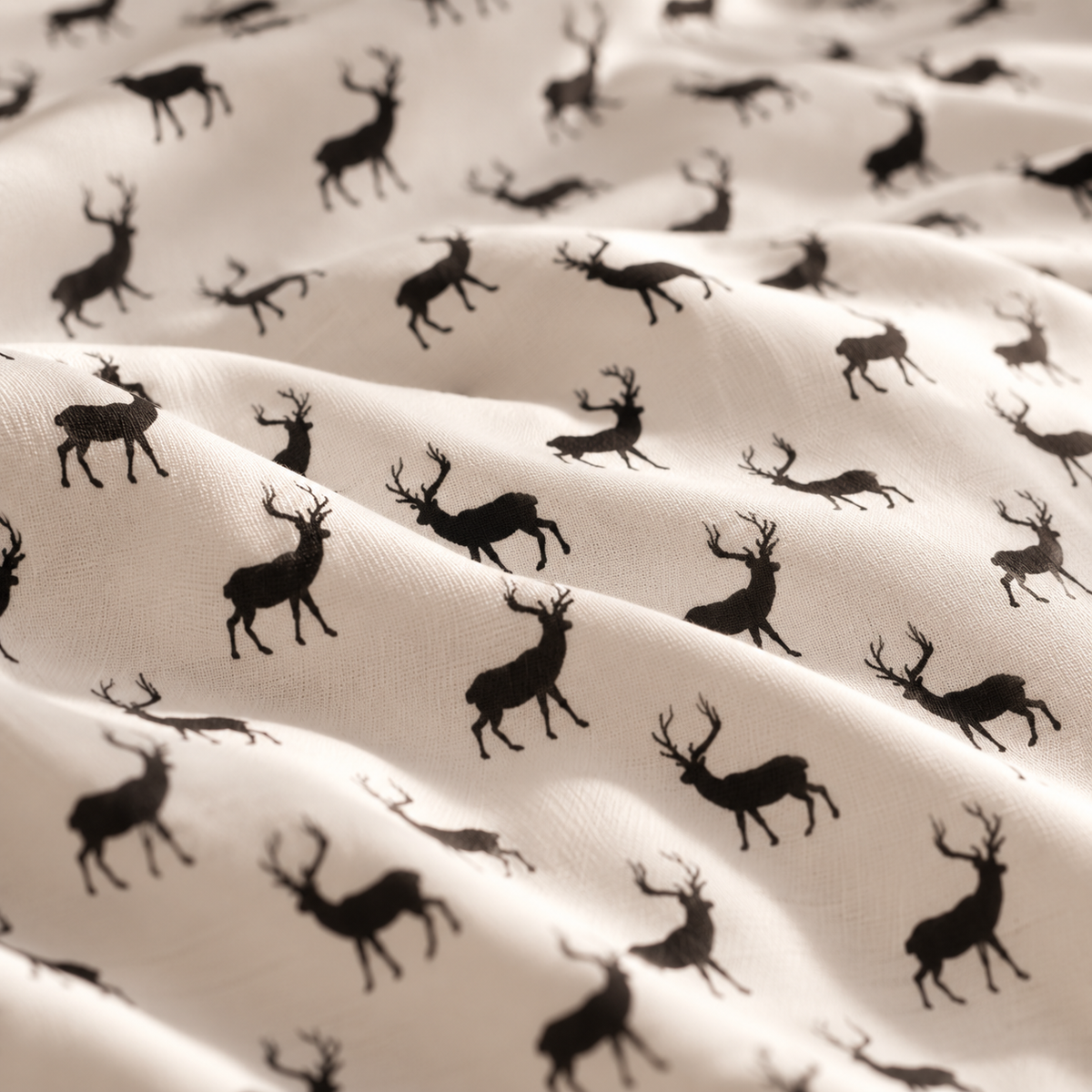 Close-up of the Black Reindeer Crib Sheet fabric showing black reindeer silhouettes on white