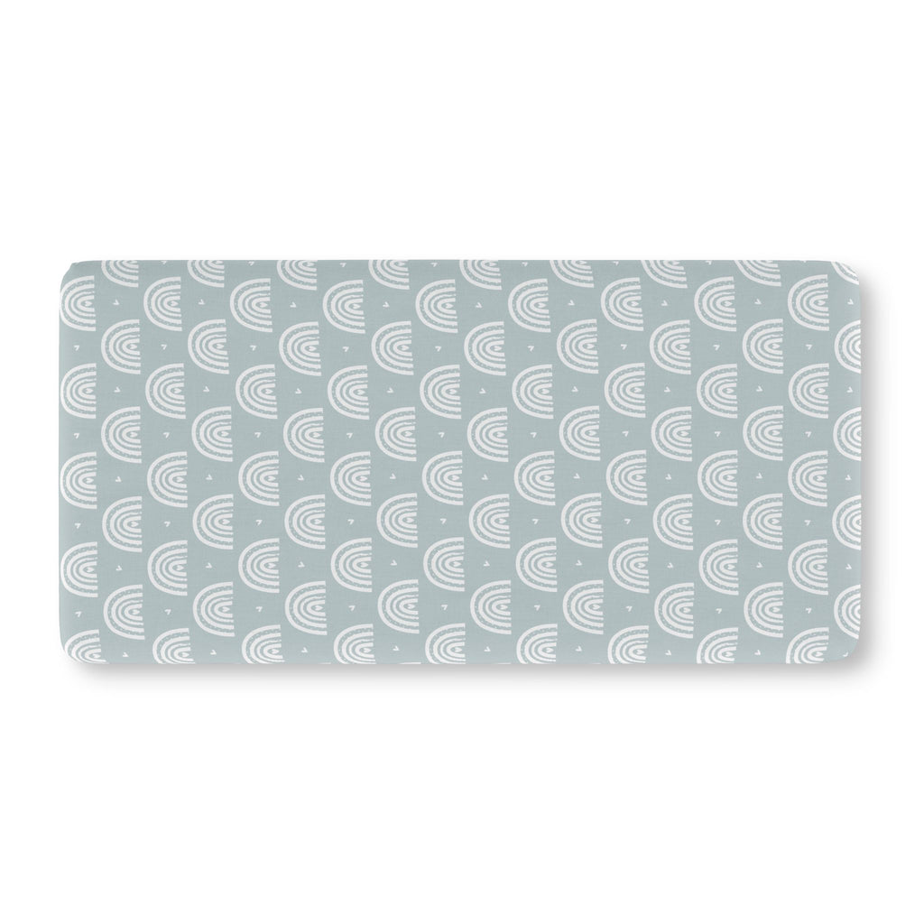 Blue Boho Rainbow Crib Sheet laid flat in Standard size with white rainbow arches on dusty blue