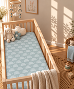 Blue Boho Rainbow Crib Sheet in a wooden crib in a sunlit nursery