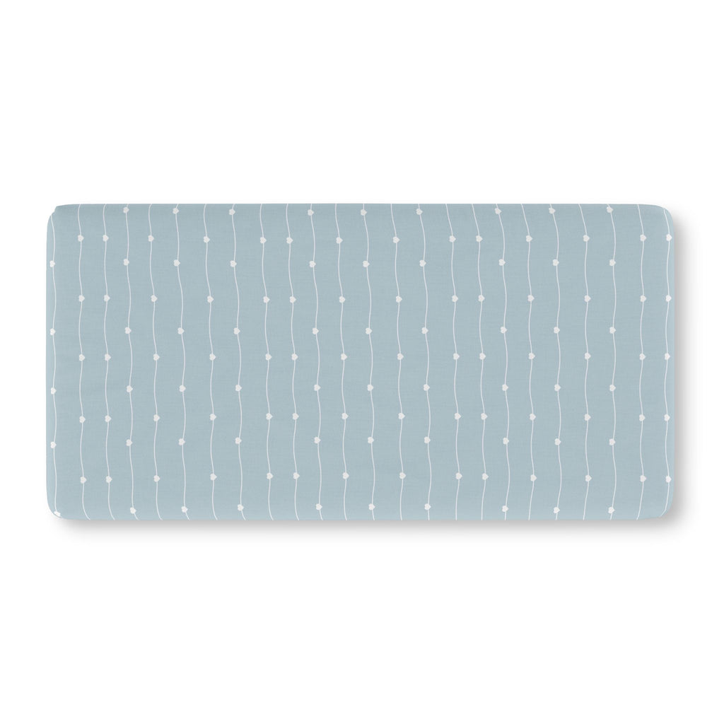 Blue Heart Stripe Crib Sheet laid flat in Standard size with wavy white lines and tiny hearts on dusty blue