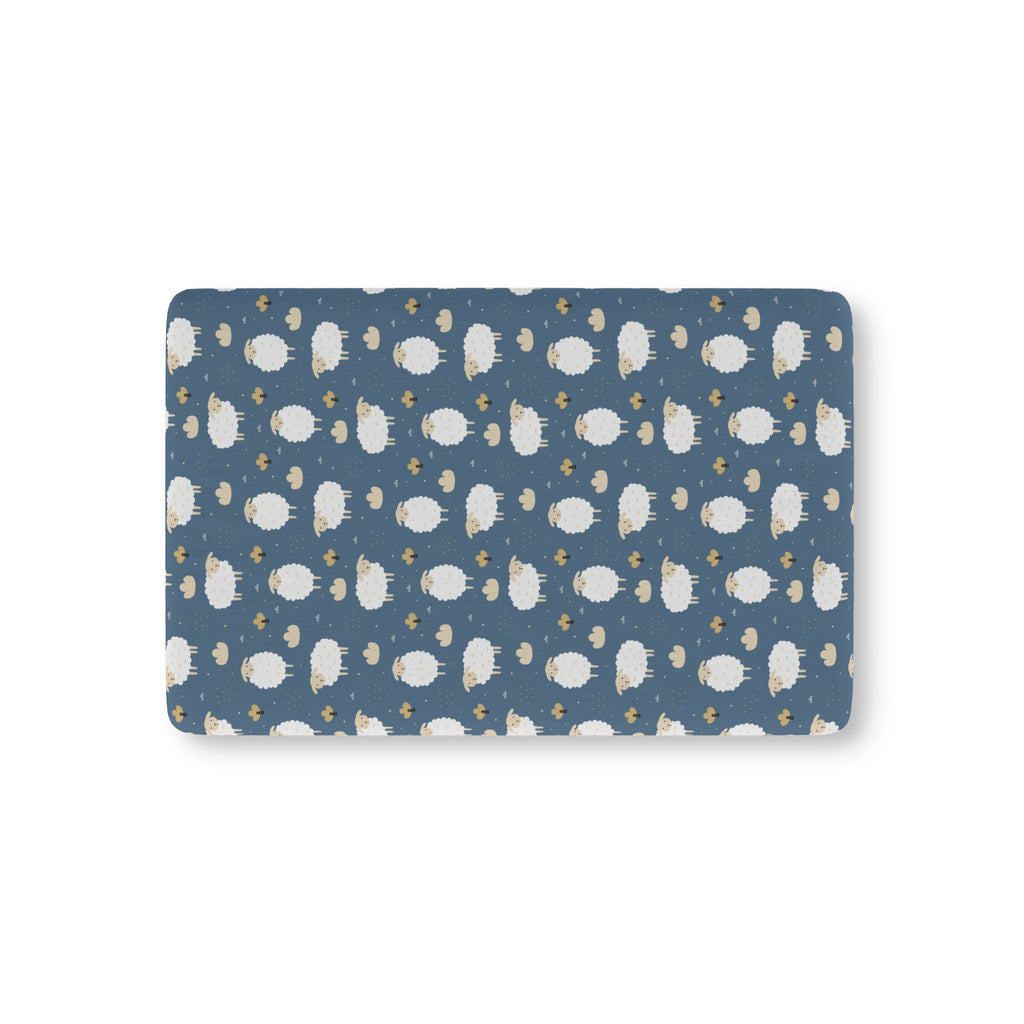 Blue Sheep Crib Sheet laid flat in Mini size with white woolly sheep and tan clouds on dusty blue
