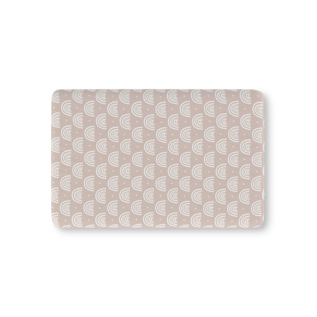 Blush Boho Rainbow Crib Sheet laid flat in Mini size with white rainbow arches on blush