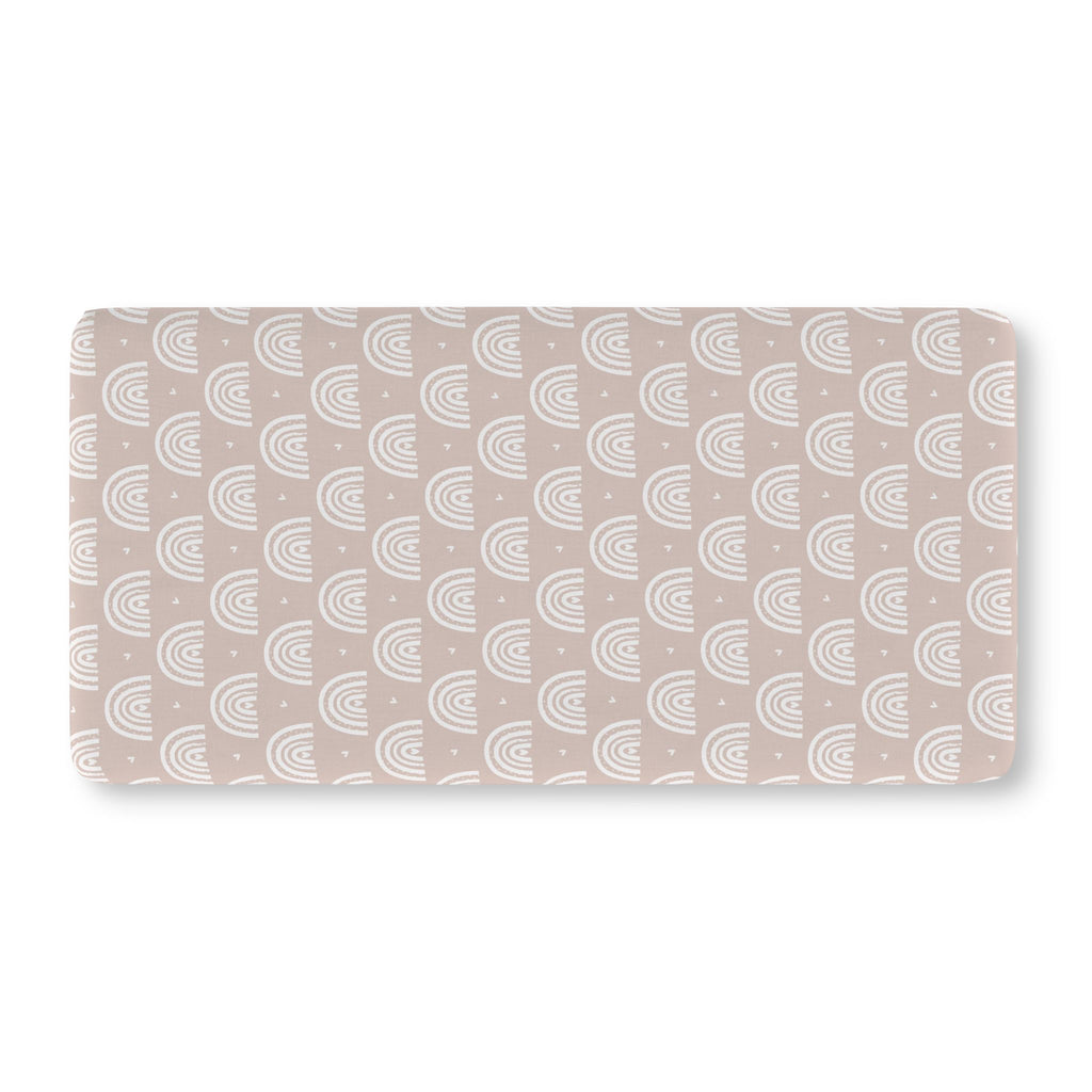 Blush Boho Rainbow Crib Sheet laid flat in Standard size with white rainbow arches on blush
