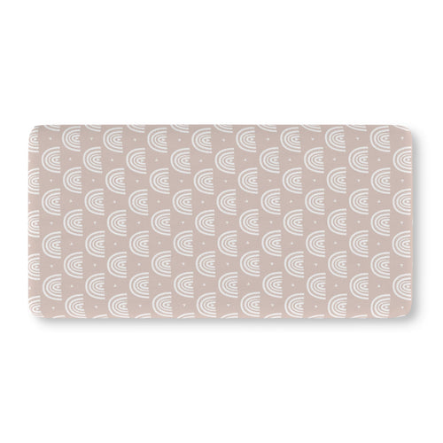 Blush Boho Rainbow Crib Sheet laid flat in Standard size with white rainbow arches on blush