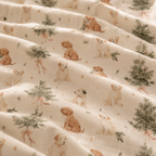 Close-up of the Christmas Puppy Crib Sheet fabric showing puppies and little pine trees on cream