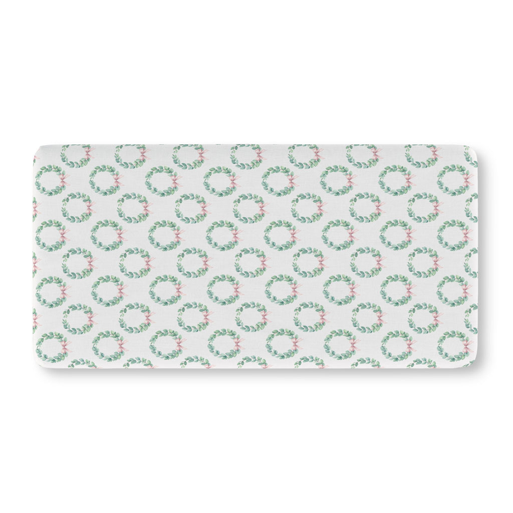 Christmas Wreath Crib Sheet laid flat in Standard size with eucalyptus wreaths and pink bows on white