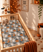 Gray Halloween Ghost Crib Sheet in a wooden crib in a sunlit nursery