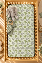Green Elephant Crib Sheet seen from above in a wooden crib