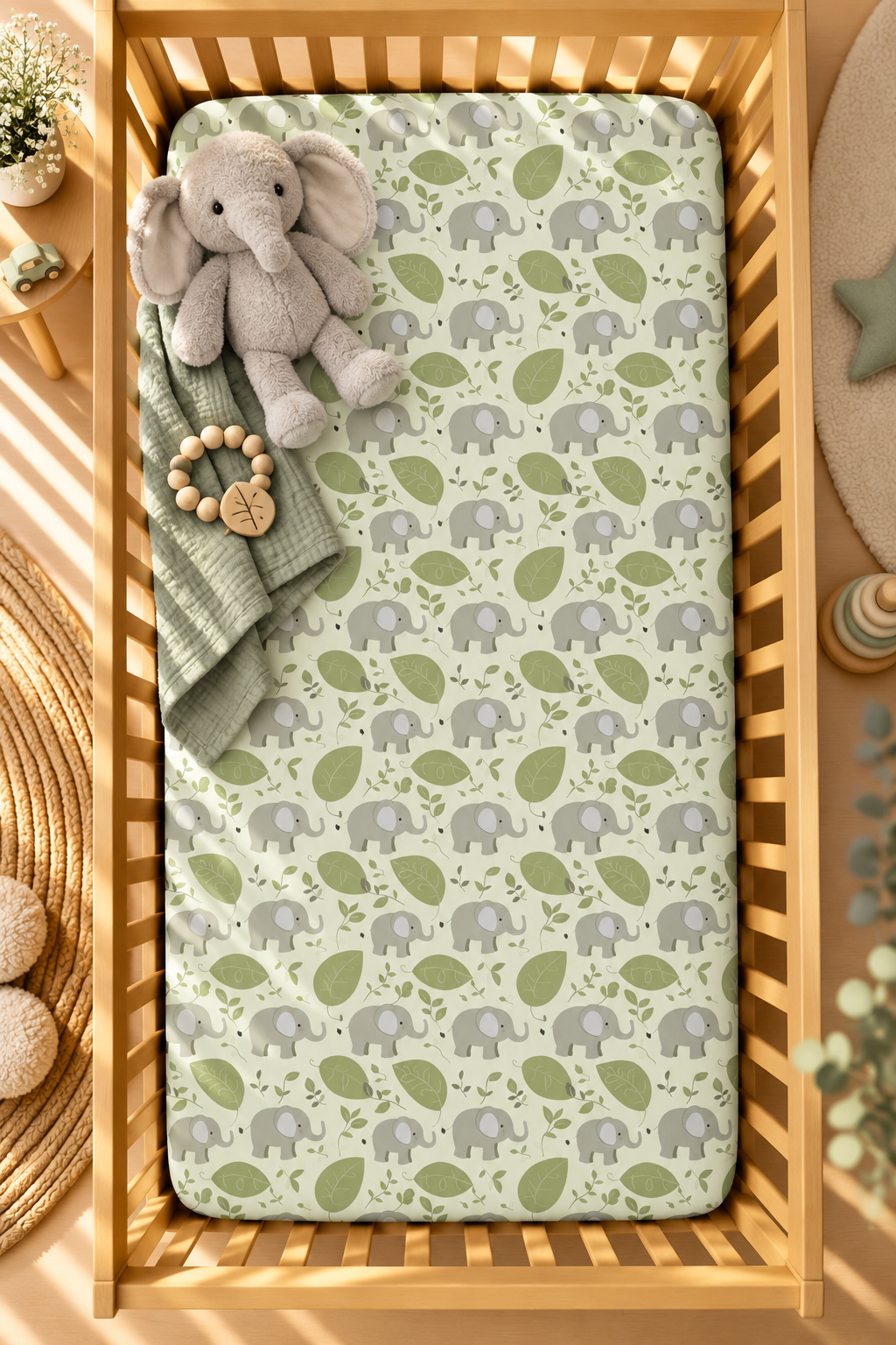 Green Elephant Crib Sheet seen from above in a wooden crib