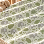 Close-up of the Green Elephant Crib Sheet fabric showing gray elephants and green leaves on pale green