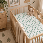 Green Pine Tree Crib Sheet on a wooden crib mattress in a woodland nursery