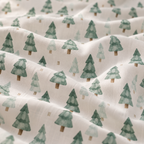 Close-up of the Green Pine Tree Crib Sheet fabric showing green watercolor pine trees on white