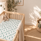 Green Pine Tree Crib Sheet in a wooden crib in a sunlit nursery