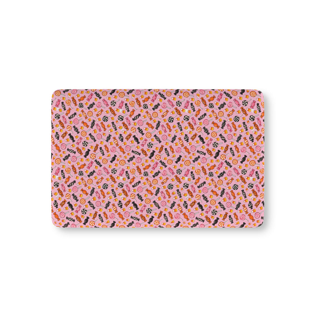 Halloween Candy Crib Sheet laid flat in Mini size with wrapped candy, lollipops and candy corn on pink