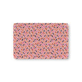 Halloween Candy Crib Sheet laid flat in Mini size with wrapped candy, lollipops and candy corn on pink