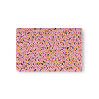 Halloween Candy Crib Sheet laid flat in Mini size with wrapped candy, lollipops and candy corn on pink