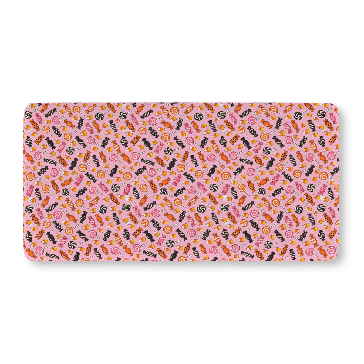 Halloween Candy Crib Sheet laid flat in Standard size with wrapped candy, lollipops and candy corn on pink