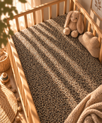 Leopard Print Crib Sheet fitted in a wooden crib with a plush toy