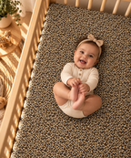 Smiling baby lying on the Leopard Print Crib Sheet