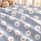 Close-up of the Light Blue Sheep Crib Sheet fabric showing round fluffy sheep, wavy lines and tiny stars on light blue