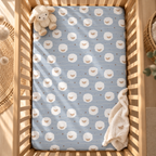 Light Blue Sheep Crib Sheet seen from above in a wooden crib