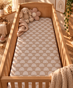 Mauve Boho Rainbow Crib Sheet on a wooden crib mattress in a boho nursery