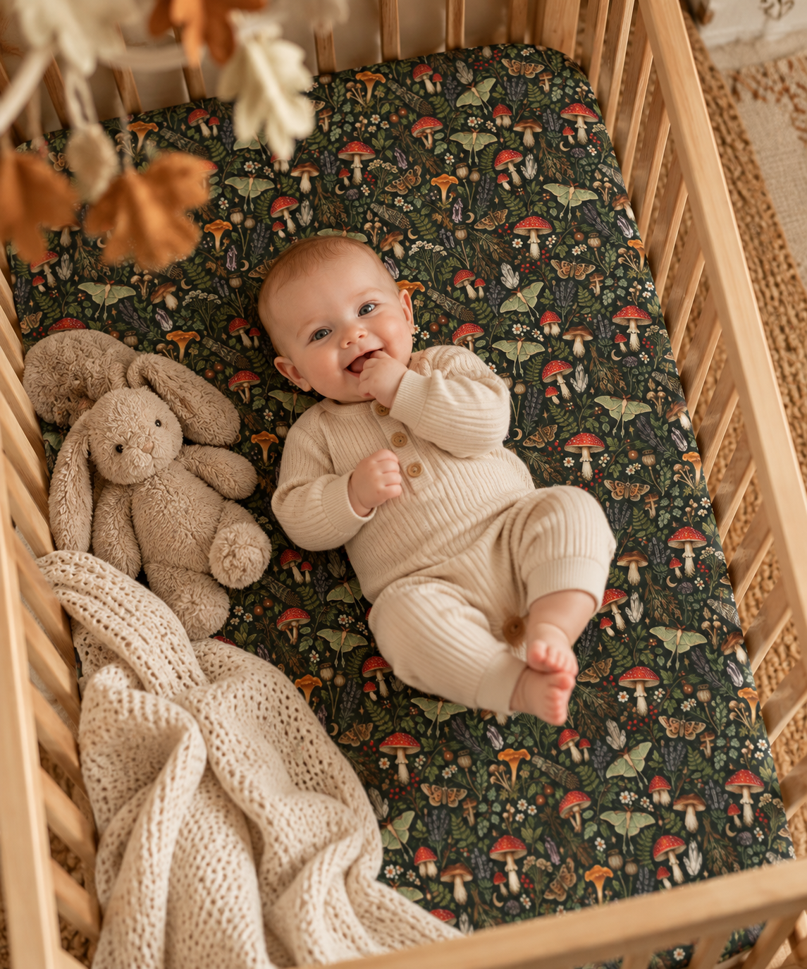 Smiling baby lying on the Mushroom Woodland Crib Sheet