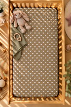 Olive Heart Crib Sheet seen from above in a wooden crib