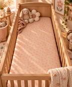 Peach Polka Dot Crib Sheet on a wooden crib mattress in a baby girl nursery