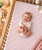Smiling baby lying on the Pink Candy Stripe Crib Sheet