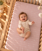 Smiling baby lying on the Pink Heart Stripe Crib Sheet