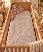Pink Leopard Print Crib Sheet on a wooden crib mattress in a baby girl nursery