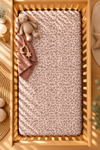 Pink Leopard Print Crib Sheet seen from above in a wooden crib