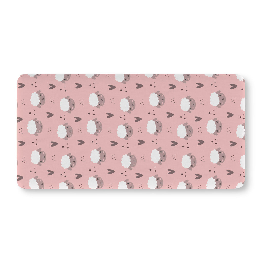 Pink Sheep Crib Sheet laid flat in Standard size with white sheep faces and little hearts on dusty pink