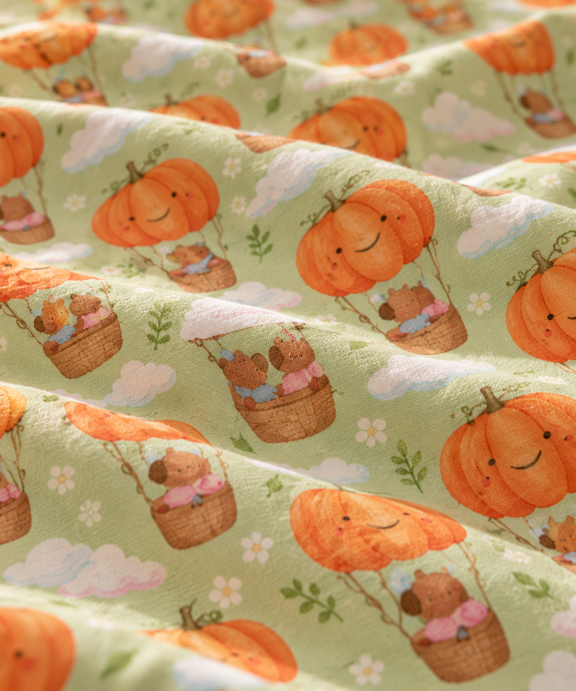 Close-up of the Pumpkin Bear Crib Sheet fabric showing teddy bears in pumpkin hot air balloons on light green