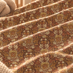 Close-up of the Rust Boho Floral Crib Sheet fabric showing boho flowers in mustard and cream on rust