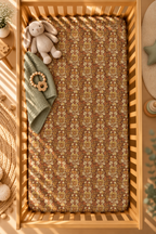 Rust Boho Floral Crib Sheet seen from above in a wooden crib