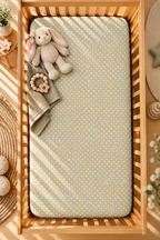 Sage Polka Dot Crib Sheet seen from above in a wooden crib