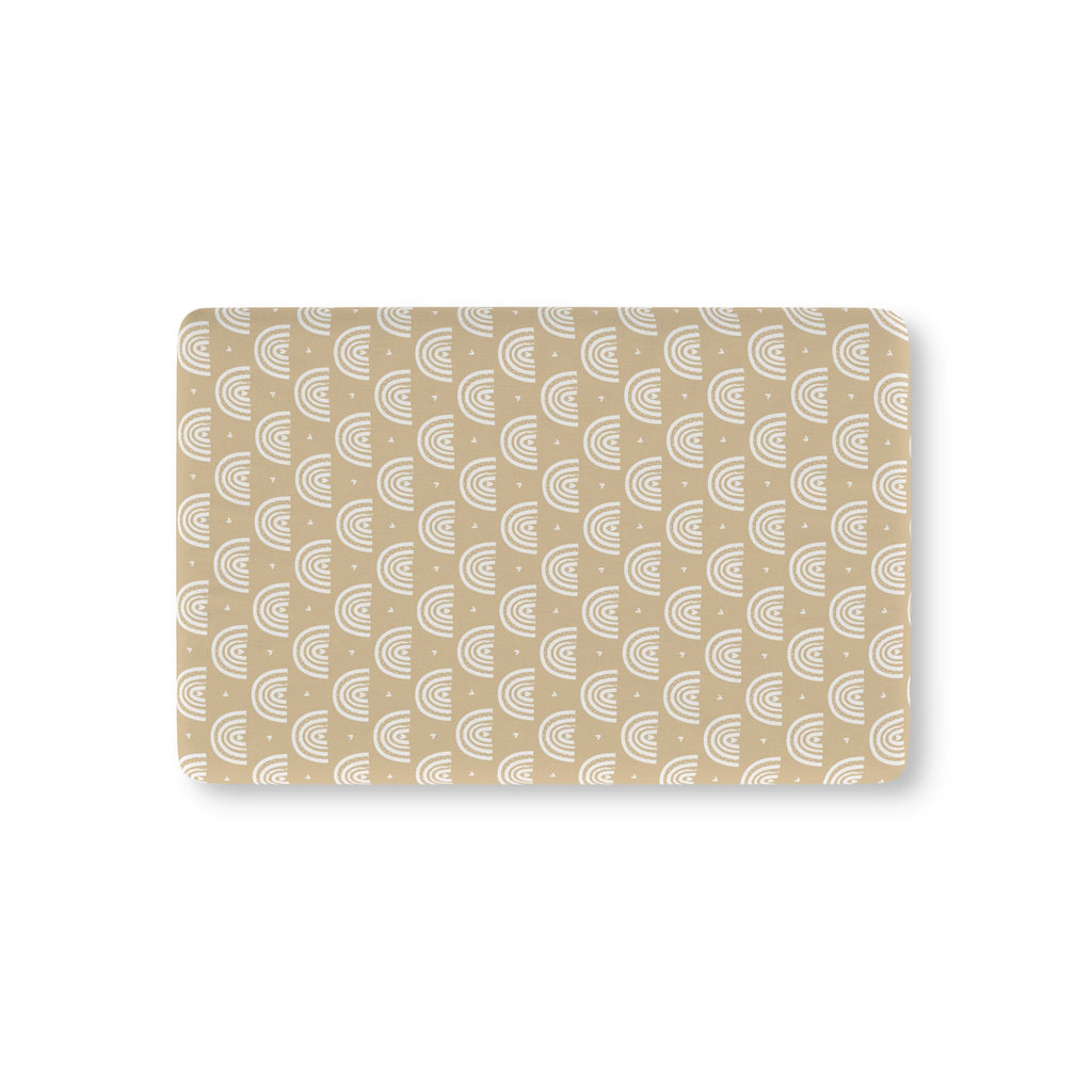 Tan Boho Rainbow Crib Sheet laid flat in Mini size with white rainbow arches on tan