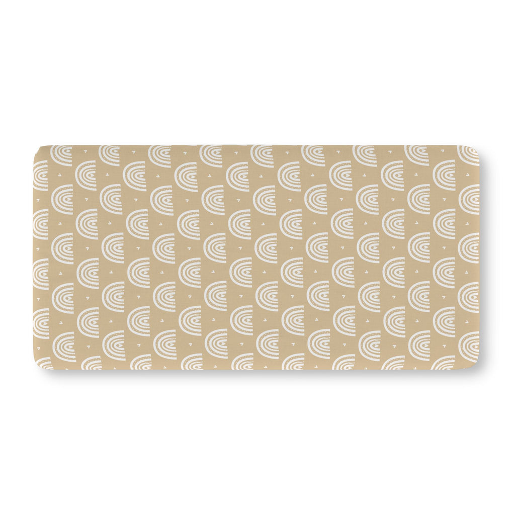Tan Boho Rainbow Crib Sheet laid flat in Standard size with white rainbow arches on tan
