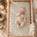 Baby lying on the Winter Penguin Crib Sheet