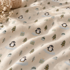 Close-up of the Winter Penguin Crib Sheet fabric showing penguins and pine trees on pale sage